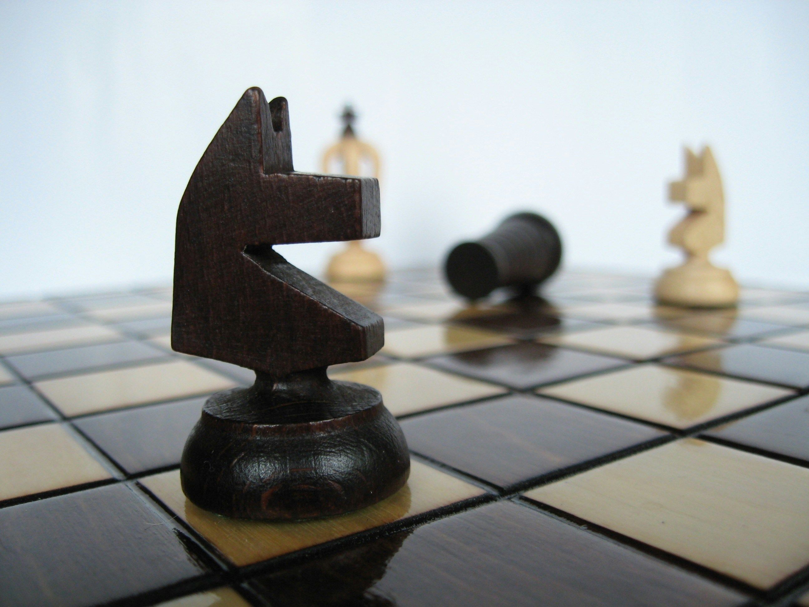 a close up of a chess board with pieces on it