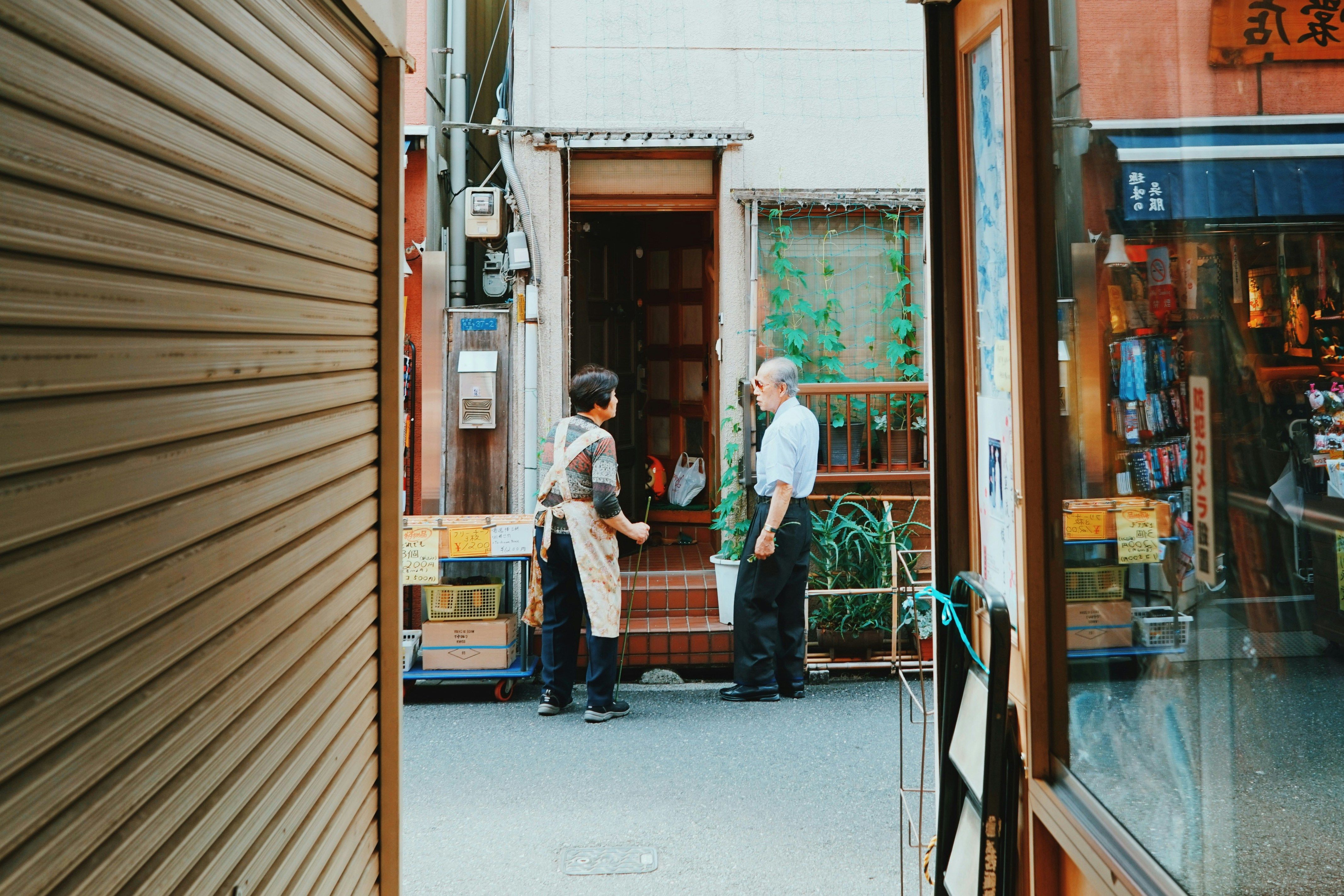 a couple of men standing outside of a store