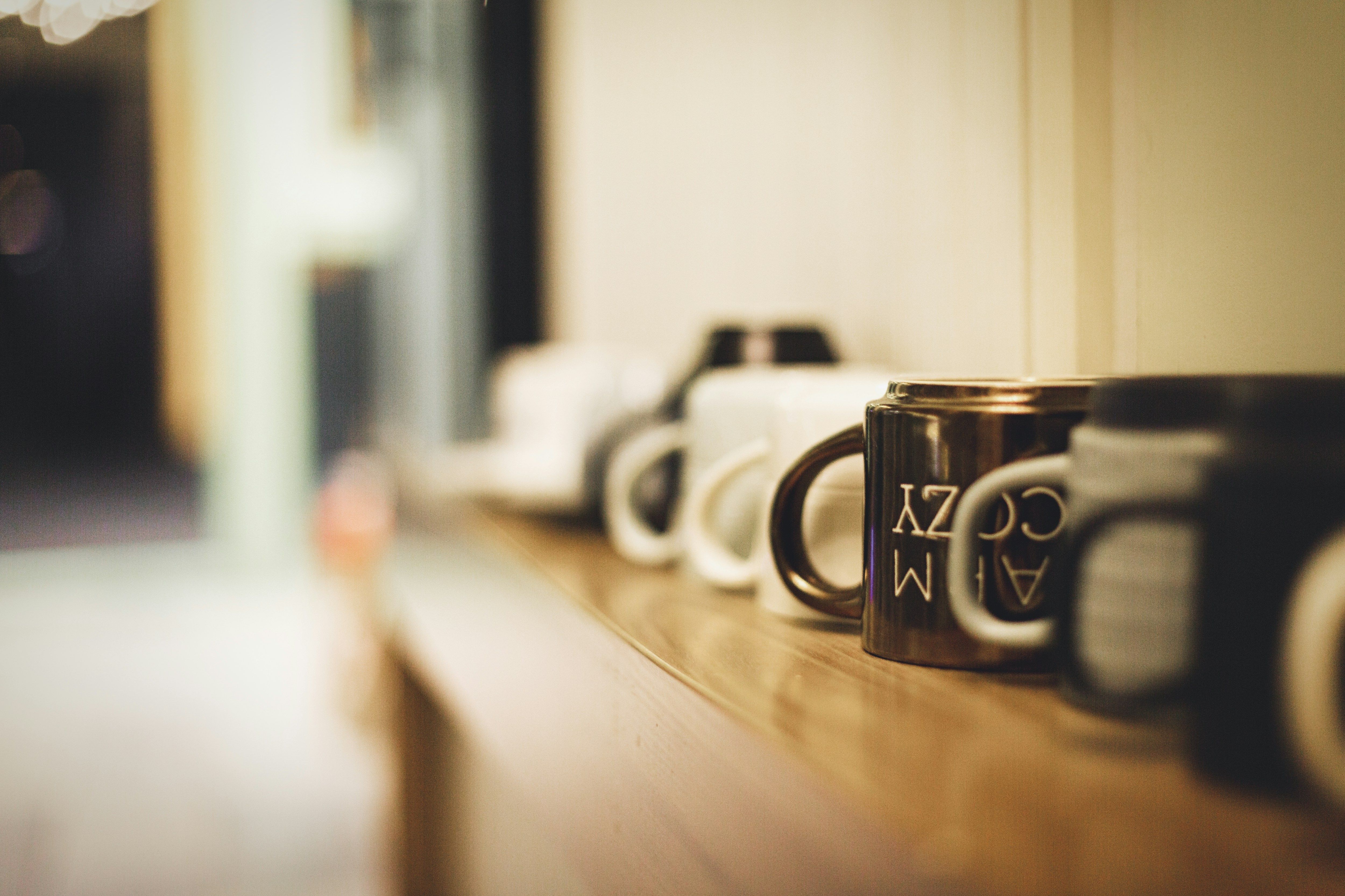 a row of coffee mugs sitting on top of a wooden counter