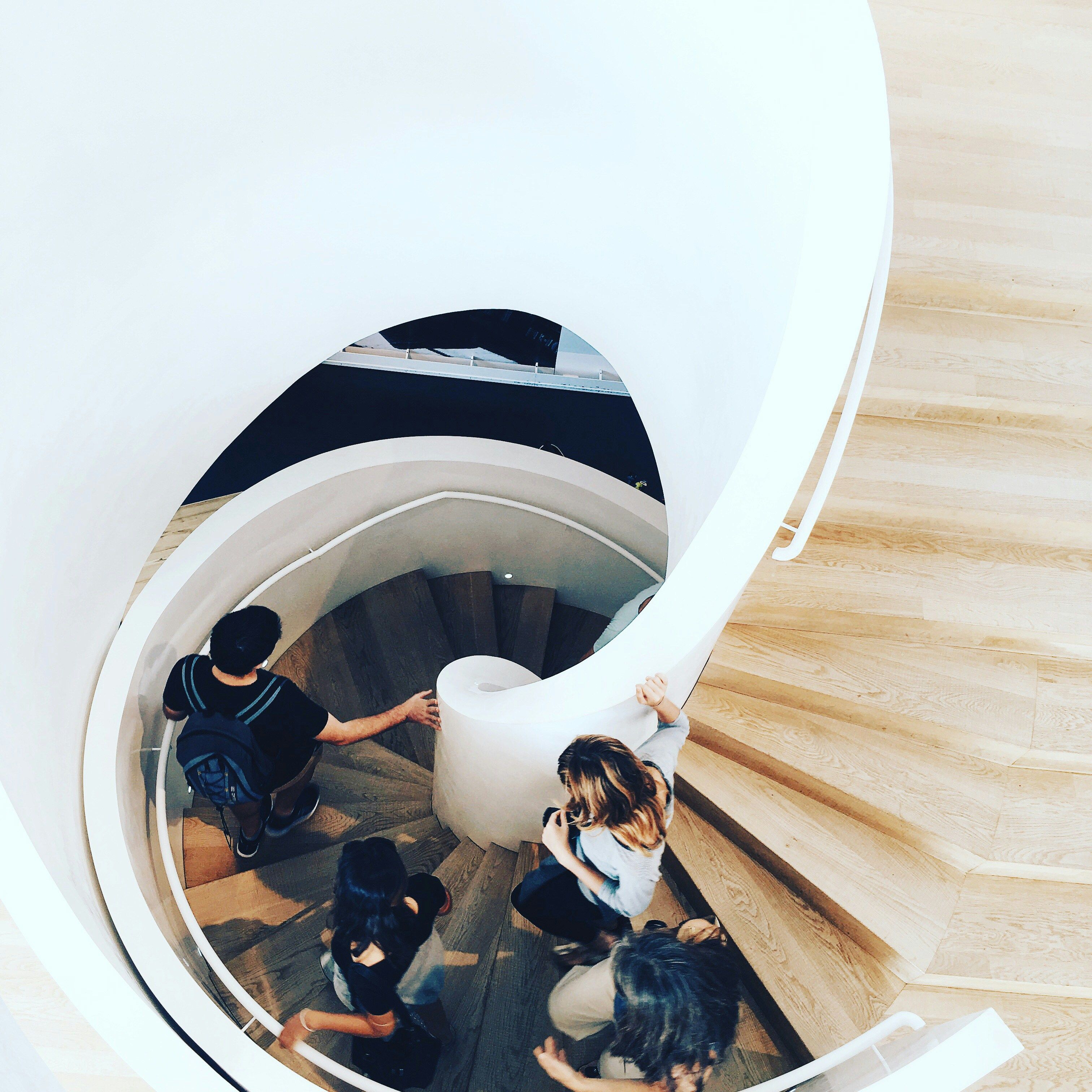 a group of people walking down a spiral staircase